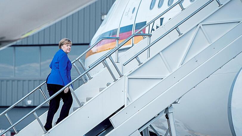 Kritischer Blick zurück: Allein steigt Bundeskanzlerin Angela Merkel (CDU) nach ihrem Blitzbesuch bei Trump die Gangway zum Airbus A340 für den Rückflug nach Berlin hinauf.