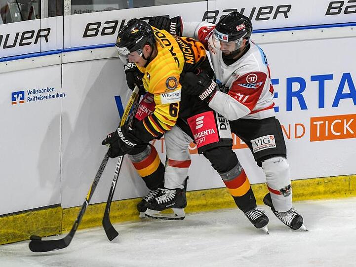 Marc Michaelis (l) kämpft mit dem Österreicher Dominique Heinrich um den Puck.