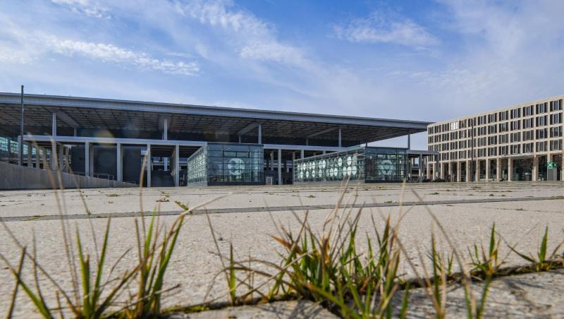 Gras wächst zwischen den Fugen auf einem Platz vor dem Terminal des Hauptstadtflughafens Berlin Brandenburg Willy Brandt (BER). Gras wächst zwischen den Fugen auf einem Platz vor dem Terminal des Hauptstadtflughafens Berlin Brandenburg Willy Brandt (BER).
