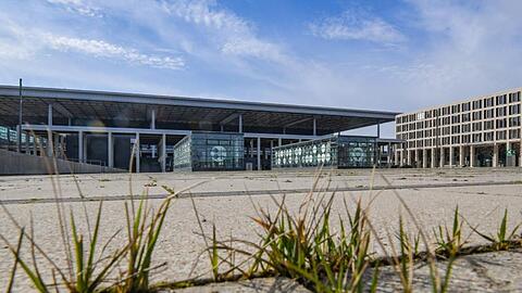 Gras wächst zwischen den Fugen auf einem Platz vor dem Terminal des Hauptstadtflughafens Berlin Brandenburg Willy Brandt (BER).