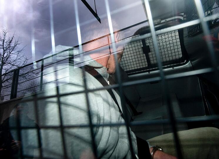 Ein Mann wird am Freitag (30.12.2011) in einem Polizeibus in das Justizzentrum Augsburg (Schwaben) gefahren.