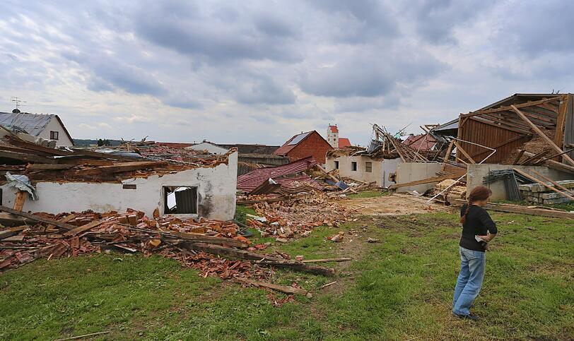 Eine Frau steht am 14.05.2015 in Gebenhofen in der Gemeinde Affing im Landkreis Aichach Friedberg (Bayern) vor zerstörten landwirtschaftlichen Gebäuden.