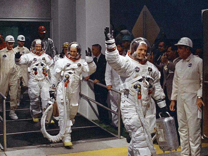 Neil Armstrong (r-l), Michael Collins und Buzz Aldrin auf dem Weg zu einem Wagen, der sie zur Startrampe im Kennedy Space Center bringen wird.