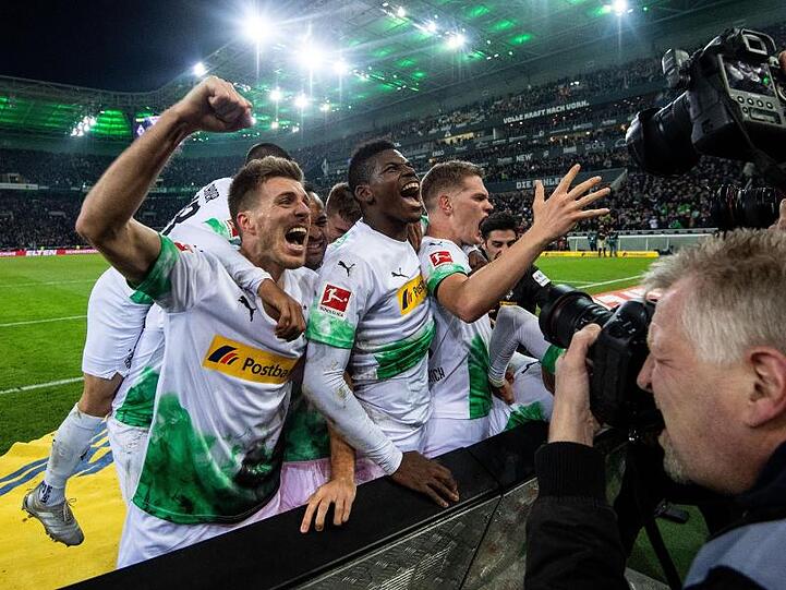 Die Gladbacher Spieler feiern den Treffer zum 2:1 gegen den FC Bayern München durch Ramy Bensebaini (r).