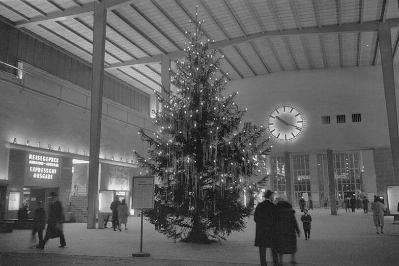 Ein stattlicher Christbaum mitten in der Schalterhalle des alten Hauptbahnhofs, 1958. Manche M&uuml;nchner erinnern sich noch: Die Treppe im Hintergrund f&uuml;hrte in ein Kino.