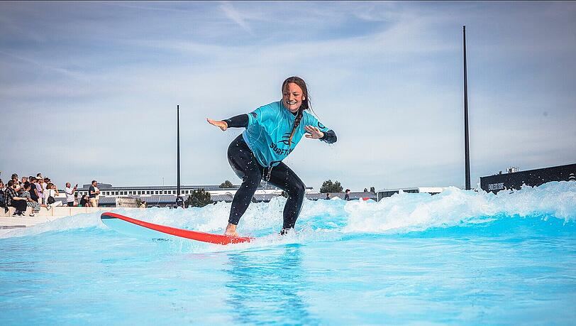 Eine Surferin genießt die perfekten Wellen in der O2 SURFTOWN MUC. Eine Surferin genießt die perfekten Wellen in der O2 SURFTOWN MUC.