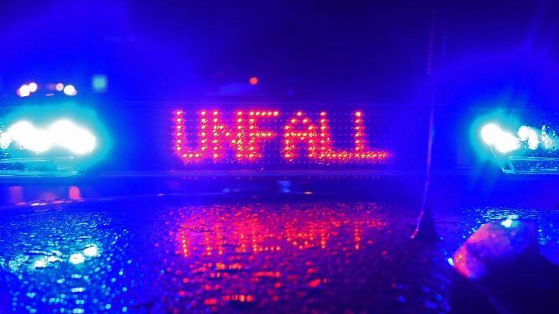 Während einer Unfallaufnahme spiegelt sich das Blaulicht und der Schriftzug "Unfall" auf dem Dach eines Polizeiwagens. Foto: Stefan Puchner/dpa