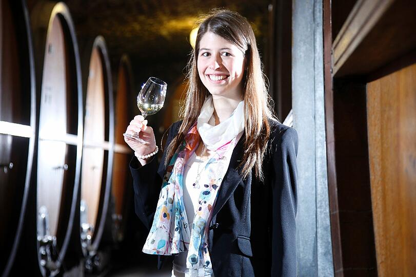 Die designierte fraenkische Weinkoenigin 2012/2013, Melanie Dietrich, posiert in Wuerzburg im Keller des Weinguts Buergerspital zum Heiligen Geist mit einem Glas Wein zwischen Faessern