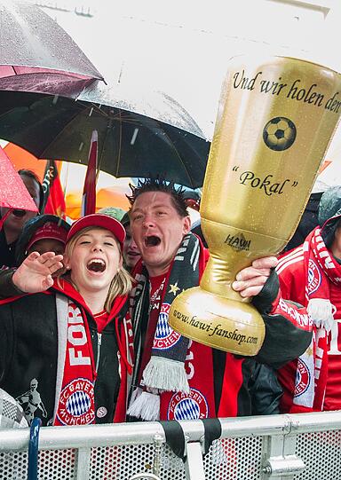 Das lange Warten auf die Pokalhelden. Es regnet und regnet und dennoch warten schon tausende Bayern-Fans auf das Eintreffen der Bayern-Stars. Die Bilder vom Marienplatz