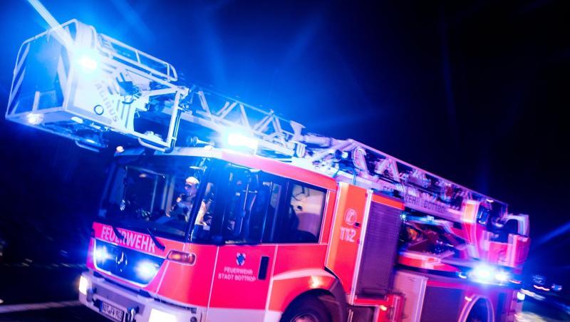 Ein Drehleiterwagen der Feuerwehr fährt mit Blaulicht an einer Unfallstelle vorbei. Foto: Marcel Kusch/dpa/Illustration