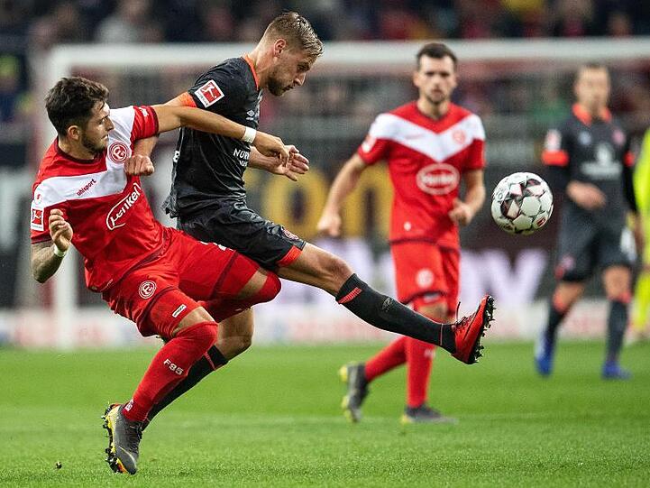 Düsseldorfs Matthias Zimmermann (l) und Nürnbergs Hanno Behrens kämpfen um den Ball.