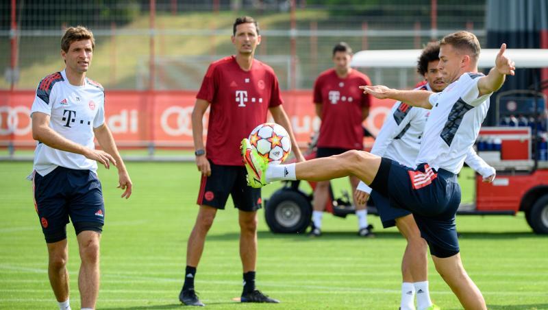 Bayerns Joshua Kimmich (r), Leroy Sane (hinten) und Thomas Müller halten den Ball hoch. Co-Trainer Dino Toppmöller beobachtet das Warm-Up.