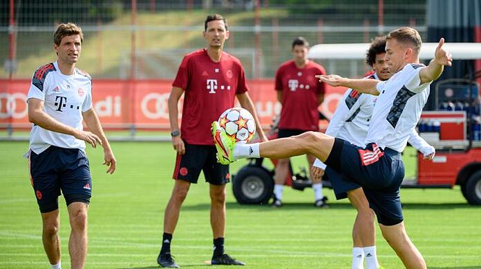 Bayerns Joshua Kimmich (r), Leroy Sane (hinten) und Thomas Müller halten den Ball hoch. Co-Trainer Dino Toppmöller beobachtet das Warm-Up.