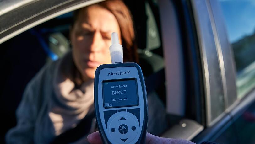Eine Frau bei einer Polizeikontrolle mit Alkoholkontrolle (Symbolbild)