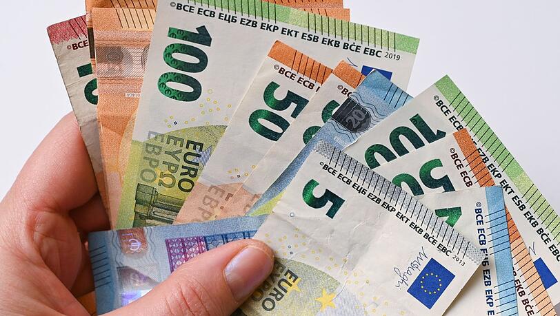Eine Frau hält Geldscheine in der Hand.
