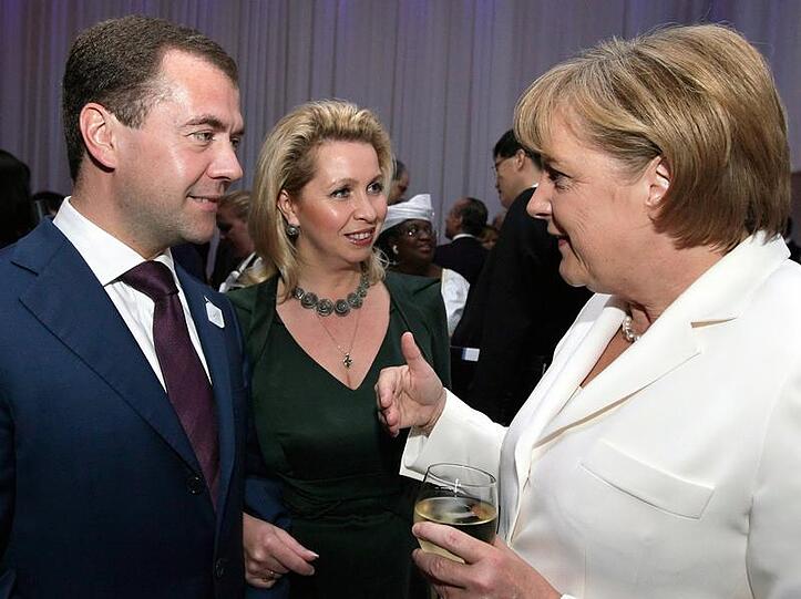 Russlands Präsident Medwedew unterhält sich mit Kanzlerin Merkel.