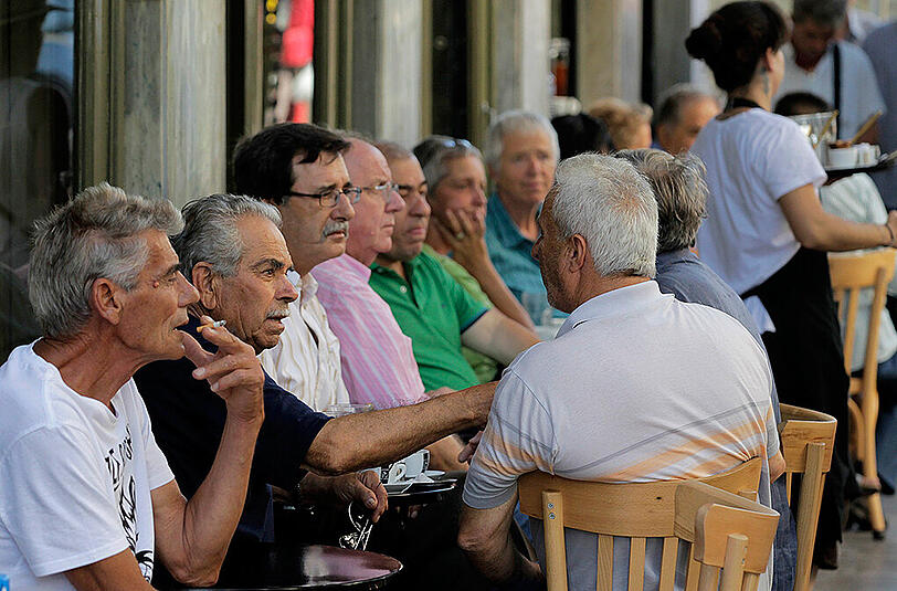 Ältere Männer diskutieren in einem Cafe in Athen.
