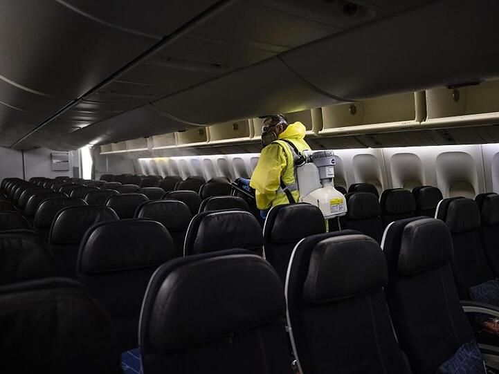 Ein Mitarbeiter des Flughafens Paris-Charles-de-Gaulle desinfiziert den Passagierraum eines Air France-Maschine.