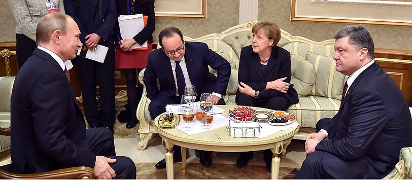 Diplomatie bei Oliven, Nüsschen und Dörrobst: Verschränkte Arme, hier bei Merkel, werden oft überinterpretiert, so Hartmann. Die Kanzlerin wirkt auf ihn nicht verschlossen, sondern eher gesammelt und konzentriert. Poroschenko schaut, wie auf vielen Bildern, ins Leere, wendet sich fast nie seinen westlichen Partnern Merkel und Hollande zu, macht einen isolierten Eindruck. Putins Blick, verschmitzt bis herausfordernd, geht direkt an seinen Rivalen.