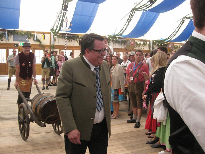 Einmarsch ins Herzkasperlzelt: FJS (alias Helmut Schleich) begrüßt seine Untertanen. Mit dem Bierfass folgt ihm Stadtrat Wolfgang Zeilnhofer-Rath, der auf der Oidn Wiesn als Schankkellner arbeitet.