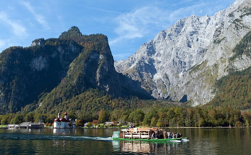 Mit traditionellem Kopfschmuck geschmückt fahren die Kühe über den Königssee ihrem Winterquartier entgegen.