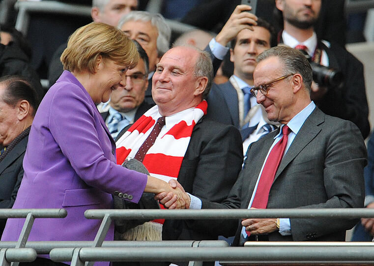 Bundeskanzlerin Angela Merkel begrüßt die Bayern-Verantwortlichen Karl-Heinz Rummenigge (rechts) und Uli Hoeneß am Rande des Champions-League-Finales FC Bayern gegen Borussia Dortmund im Londoner Wembley-Stadion.