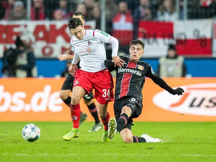 Kölns Noah Katterbach (l) zieht Leverkusens Kai Havertz davon.