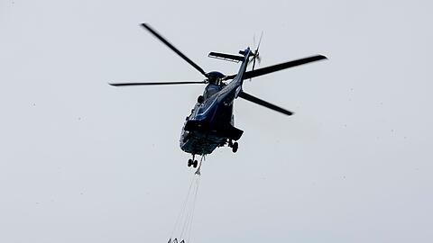 Ein Löschhubschrauber der Bundespolizei fliegt über dem Zeithainer Tagebau und nimmt Wasser auf, um den Waldbrand Gohrischheide zu bekämpfen.