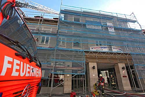 Ein Feuerwehrauto steht am Sonntag vor einem durch einen Brand zerstörten Gebäudekomplexes  in der Innenstadt von Ansbach.