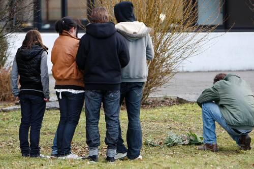 Fassungslose Jugendliche trauern vor  ihrer Schule.