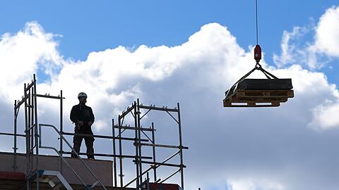 Ein Arbeiter dirigiert auf einer Baustelle einen Kran. Das Wirtschaftswachstum in Deutschland nimmt laut Bundesbank im Frühjahr leicht zu. Aber dann?