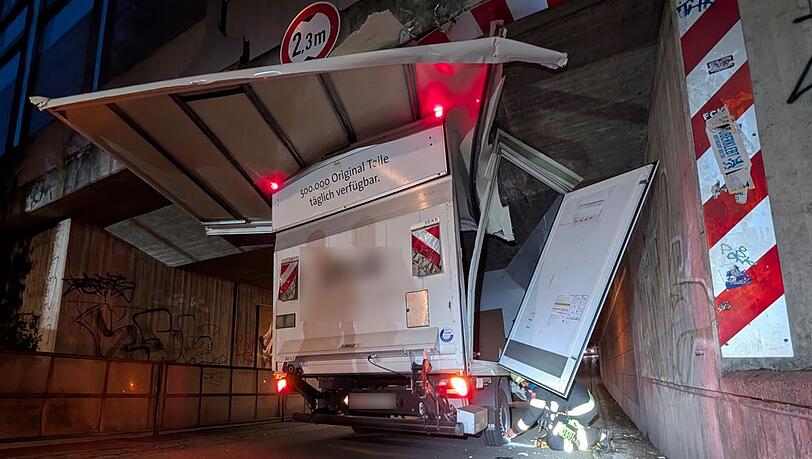 Feuerwehrleute machen den festgefahrenen Transporter in der Bahnunterführung wieder flott.