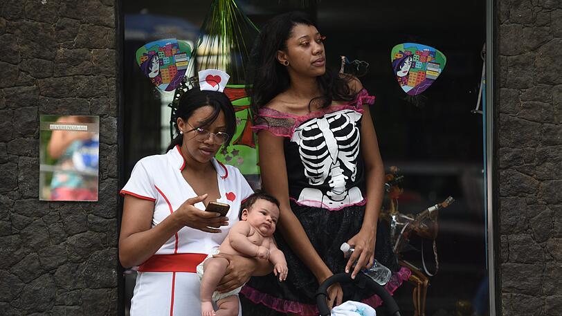 Rio de Janeiro: Zwei kostümierte Frauen nehmen zusammen mit einem Baby am Karneval teil.