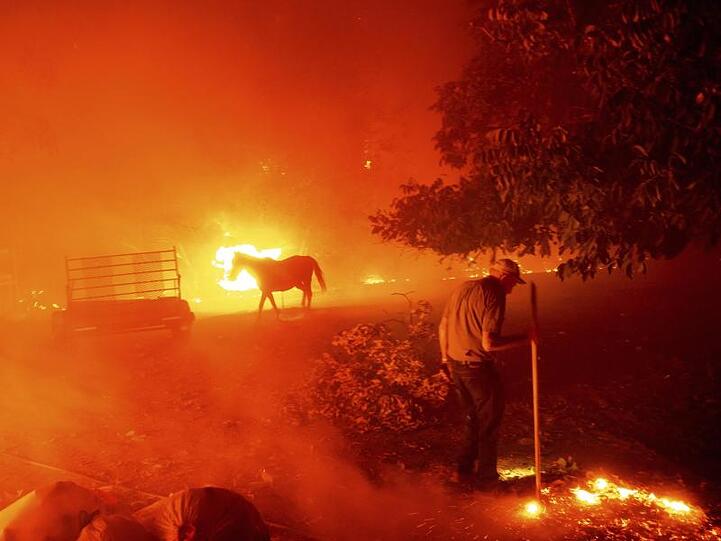 Der 84-Jährige Bill Nichols versucht in Vacaville, sein Haus vor den Flammen zu retten.
