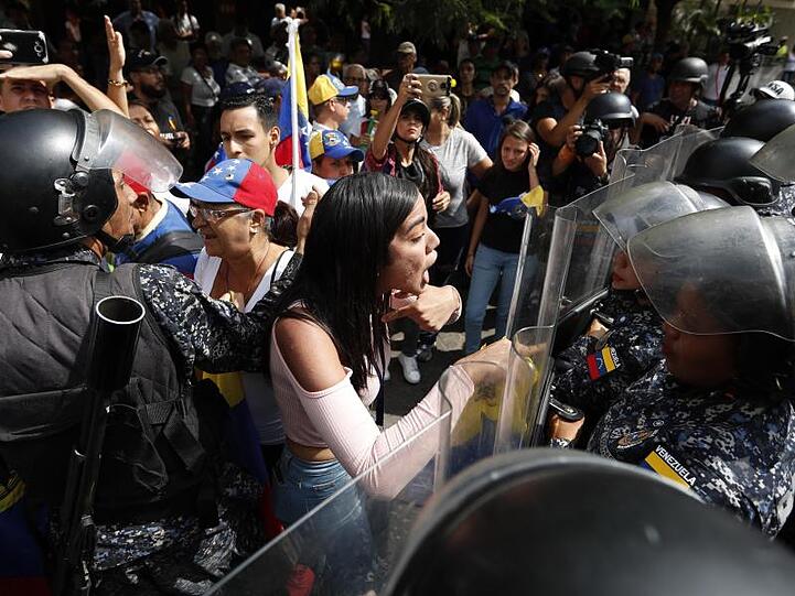 Eine Frau konfrontiert venezolanische Polizisten, die Teilnehmer einer Demonstration gegen die sozialistische Regierung von Präsident Maduro blockieren.