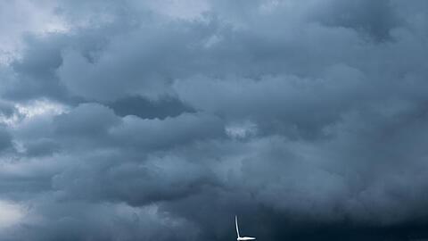 Eine Gewitterzelle mit dunklen Wolken zieht über Windräder in der Region Hannover hinweg.