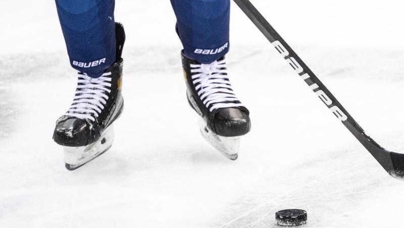 Ein Eishockeyspieler spielt den Puck.