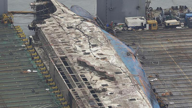 Bergung: Das gehobene Wrack der gesunkenen Fähre "Sewol" liegt an der Küste von Jindo (Südkorea) zwischen zwei Bergungsschiffen.
