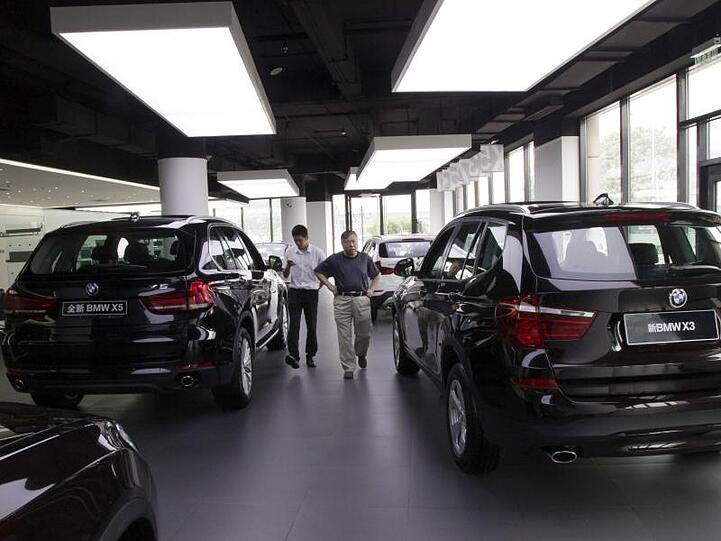 Ein Kunde (r) schaut sich bei einem BMW-Händler verschiedene Modelle an. Foto: Rolex Dela Pena/EPA/Archivbild