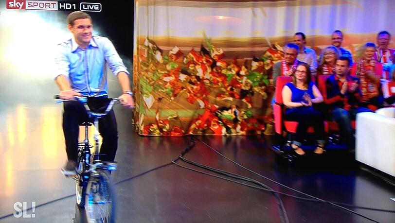 Mit dem Klapprad kommt Löwen-Profi Moritz Volz nicht nur in die Sky-Sendung "Samstag Live" eingefahren... Mit dem Klapprad kommt Löwen-Profi Moritz Volz nicht nur in die Sky-Sendung "Samstag Live" eingefahren...