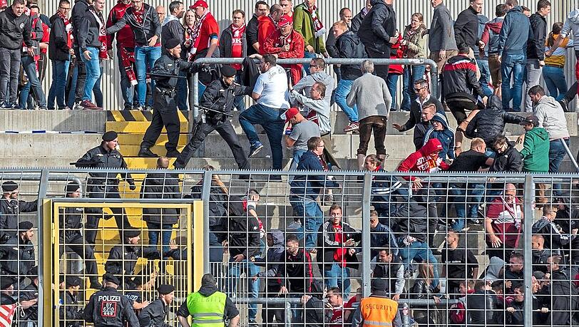 Polizisten mit gezücktem Schlagstock stürmen nach Schlusspfiff in den Gästeblock des Grünwalder Stadions. Polizisten mit gezücktem Schlagstock stürmen nach Schlusspfiff in den Gästeblock des Grünwalder Stadions.