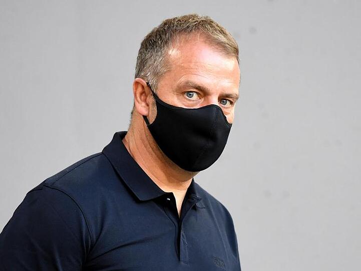 Münchens Trainer Hansi Flick betritt vor Spielbeginn mit Mundschutz die Allianz-Arena. Foto: Sven Hoppe/dpa