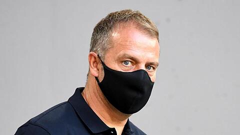 Münchens Trainer Hansi Flick betritt vor Spielbeginn mit Mundschutz die Allianz-Arena. Foto: Sven Hoppe/dpa