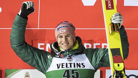 Der Erstplatzierte Karl Geiger bejubelt seinen Sieg auf dem Podium beim Weltcup in Engelberg.