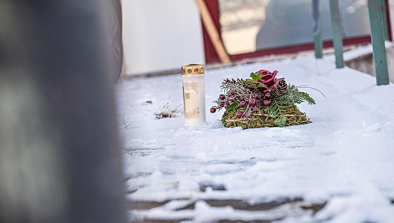 Vor dem Firmengeb&auml;ude, in dem die Leichen der beiden S&ouml;hne gefunden wurden, liegen eine Kerze und ein Kranz.