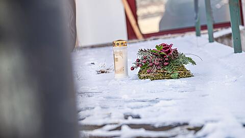 Vor dem Firmengeb&auml;ude, in dem die Leichen der beiden S&ouml;hne gefunden wurden, liegen eine Kerze und ein Kranz.