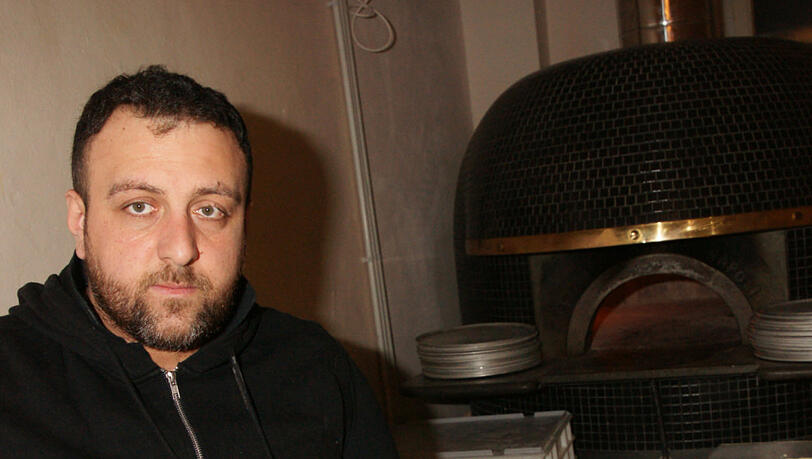 Pizzabäcker Alessandro schiebt die Teigscheibe in den extra aus Italien angelieferten Ofen. In nur 90 Sekunden ist sie dann fertig. Pizzabäcker Alessandro schiebt die Teigscheibe in den extra aus Italien angelieferten Ofen. In nur 90 Sekunden ist sie dann fertig.