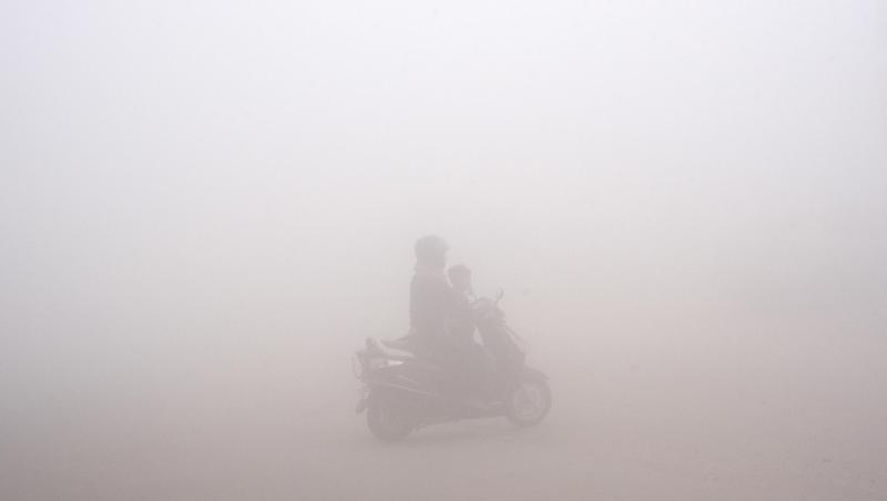 Smog in Delhi: Eine Frau bringt ihr Kind zur Schule. Smog in Delhi: Eine Frau bringt ihr Kind zur Schule.