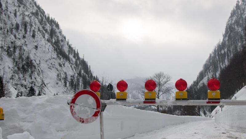 Ein Schranke versperrt die Zufahrt zu einer verschneiten und gesperrten Straße, die die Ortschaft Ruhpolding in Richtung Reit im Winkl verbindet.