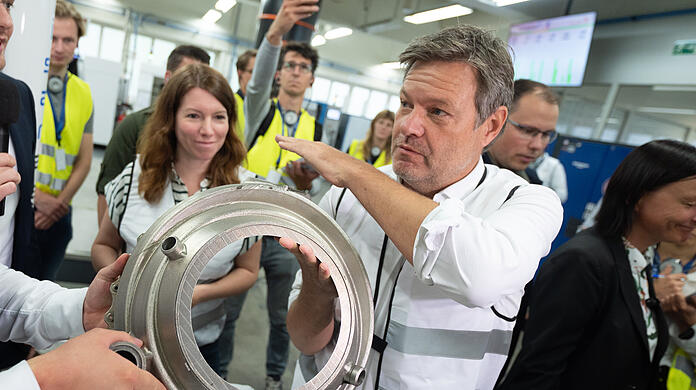 Viele Teile, die Wirtschaftsminister Robert Habeck (rechts) bei Isar Aerospace sieht, kommen aus dem 3-D-Drucker. Die Gründer Josef Fleischmann und Daniel Metzler zeigen dem Minister ihre Fabrikhalle in Ottobrunn.